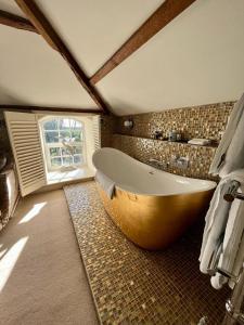 baño con bañera grande y ventana en Crug Glas Country House, en St. Davids