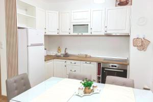 a kitchen with white cabinets and a table with chairs at Silver Apartment in Pale