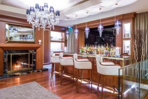 a bar with white chairs and a fireplace at Hotel Century in Geneva