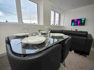 uma sala de jantar com uma mesa preta e cadeiras pretas em Pass the Keys Newly Built Modern Central Apartment em Wolverhampton