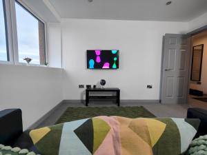 uma sala de estar com um sofá e uma televisão na parede em Pass the Keys Newly Built Modern Central Apartment em Wolverhampton