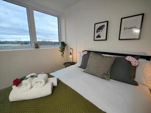 een slaapkamer met een groot bed en handdoeken bij Pass the Keys Newly Built Modern Central Apartment in Wolverhampton