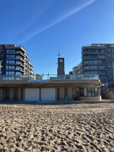a building on the beach with a clock tower at Strandstudio in hartje Koksijde in Koksijde