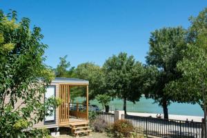 ein winziges Haus mit Pavillon neben einem Strand in der Unterkunft Camping Etang de la Bonde in Sannes