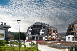 a building on a street under a cloudy sky at Fruške Residences in Vrdnik