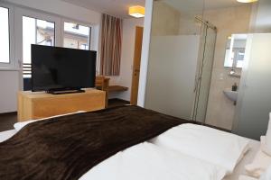 ein Hotelzimmer mit einem Bett und einem TV in der Unterkunft Apart Alpin in Tux