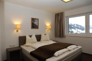 Schlafzimmer mit einem großen Bett und einem Fenster in der Unterkunft Apart Alpin in Tux