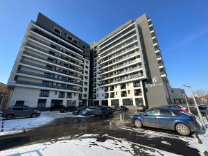 a large building with cars parked in a parking lot at Renting Solutions Q in Iaşi