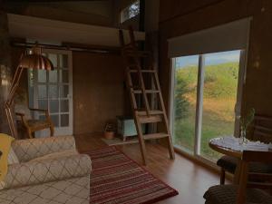 a living room with a couch and a large window at Tiny House, Cabaña in Coihaique
