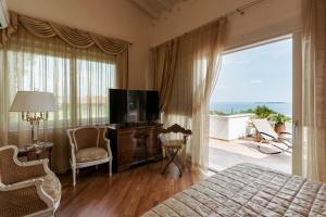 1 dormitorio con cama, TV y balcón en VILLA ELENA, en Moniga del Garda