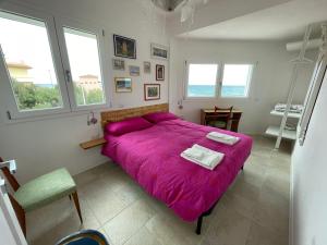 a bedroom with a large bed with a pink blanket at Sea House IUN Q7317 in Santa Maria Navarrese