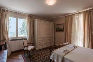 1 dormitorio con 1 cama, 1 silla y 1 ventana en VILLA ELENA, en Moniga del Garda