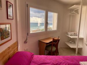 een slaapkamer met een bed, een bureau en een raam bij Sea House IUN Q7317 in Santa Maria Navarrese