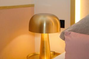 パリにあるプランセス カロリーヌのベッド横のテーブルに座る金灯