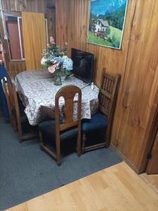 una mesa de comedor con un jarrón de flores. en Residencial familiar en Puerto Montt