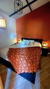 una camera con un letto con una parete arancione di La Estación del Amor ad Alora
