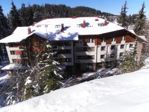 un edificio con techo cubierto de nieve en una pista de esquí en Royal House Apartments TMF en Pamporovo