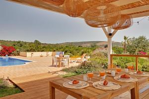 una mesa de madera con comida en la parte superior de un patio en Casa do Pomar by Portucasa, en Alte