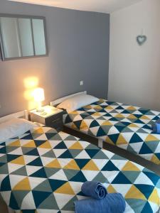 una camera da letto con due letti singoli con pavimento a scacchi di Lac Cimes a Pagéas