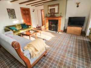a living room with a couch and a fireplace at The Coach House in Cornhill-on-tweed