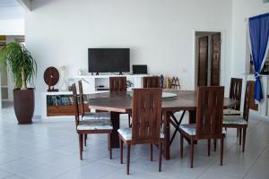uma sala de jantar com uma mesa de madeira e cadeiras em Casa Incrível na Praia de Jacumã por Carpediem em Ceará-Mirim