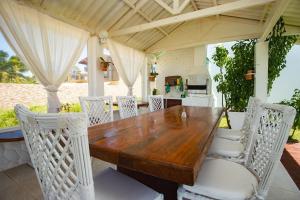 Casa Incrível na Praia de Jacumã por Carpediem في Ceará-Mirim: طاولة وكراسي خشبية على الفناء