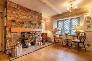 a living room with a stone fireplace and chairs at The Old Forge in Totnes