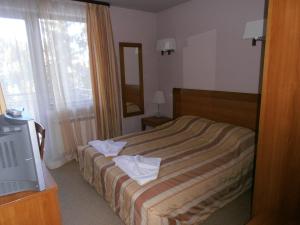a hotel room with a bed with towels on it at Royal House Apartments TMF in Pamporovo