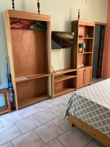 1 dormitorio con estanterías de madera y 1 cama en Caribbean Comfort, en Puerto Viejo