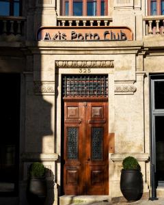 un edificio con una porta in legno con un cartello sopra di Axis Porto Club Aliados a Porto