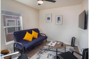a living room with a blue couch and a table at Adorable 2BR Guesthouse Close to Riverwalk and DT in San Antonio