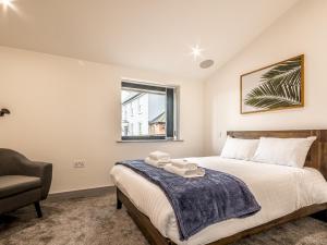 a bedroom with a bed and a chair and a window at Pass the Keys Luxury holiday home in Exmouth with parking in Exmouth
