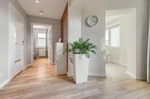 przedpokój z lodówką i zegarem na ścianie w obiekcie Apartamenty MUNN 6 Szczecin w Szczecinie
