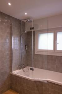 een badkamer met een douche en een glazen deur bij Logis Golfe Hotel in Vannes