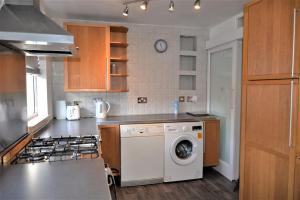 a kitchen with a washing machine and a stove at London Zone 2, 2 Bedroom House in London