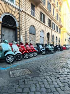 ローマにあるAureliana Apartmentsの建物前に停車する一列の二輪車