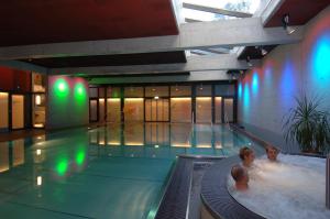 two people in a swimming pool in a building at Hotel Ländli in Oberägeri +28 photos