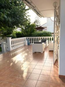 a patio with white chairs and a white fence at Villa dei Gelsi in Leporano Marina