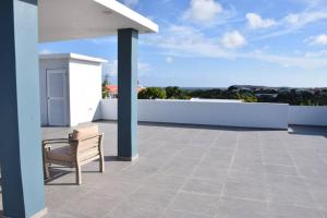 krzesło siedzące na dachu domu w obiekcie CG Apartment - Turtuga w mieście Willemstad