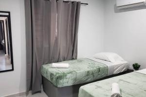 sypialnia z 2 łóżkami i oknem z zasłonami w obiekcie CG Apartment - Turtuga w mieście Willemstad