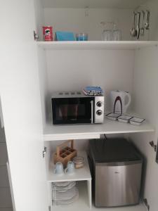 a microwave sitting on a shelf in a kitchen at Ocean room @ 66 Fynbos in Mossel Bay