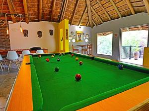 a pool table with balls on it in a room at Kruger Park Hostel in Marloth Park