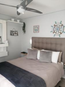 a bedroom with a large bed with a ceiling fan at Ocean room @ 66 Fynbos in Mossel Bay