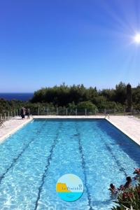 a swimming pool with the ocean in the background at LE POSEIDON VUE MER in Cassis