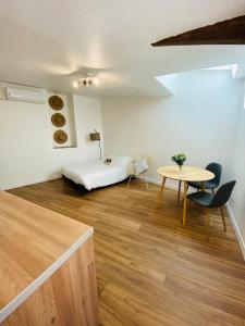 1 dormitorio con 1 cama, mesa y sillas en Les studios de Morgane hyper centre, en Valence