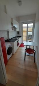 a kitchen with a table and a red chair in a room at Goito Gallery in La Spezia