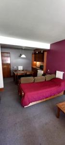 een slaapkamer met een groot bed en een rode deken bij Departamento Penitentes Lomas Blancas in Los Penitentes