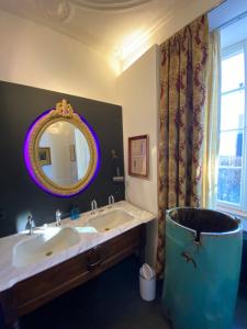 La salle de bains est pourvue d'un lavabo, d'un miroir et d'une baignoire. dans l'établissement Château de Clemency, à Clemency