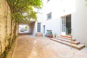 a courtyard of a white building with a bench at Vossa Bossa Higienópolis in São Paulo