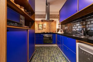 a kitchen with blue cabinets and a tile floor at Vossa Bossa Higienópolis in São Paulo